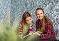 Two Teenage Girls reading fashion Magazine sitting on a couch at home Royalty Free Stock Photo