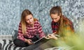 Two Teenage Girls reading fashion Magazine sitting on a couch at home Royalty Free Stock Photo