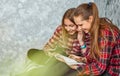 Two Teenage Girls reading fashion Magazine sitting on a couch at home Royalty Free Stock Photo