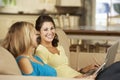 Two Teenage Girls Sitting On Sofa At Home Using Tablet Computer And Laptop Royalty Free Stock Photo