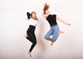 Two teenage girls smiling and jumping friends Royalty Free Stock Photo