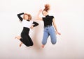 Two teenage girls smiling and jumping friends Royalty Free Stock Photo