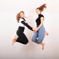 Two teenage girls smiling and jumping friends Royalty Free Stock Photo