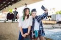 Two teenage girls taking a selfie photo on a smartphone in a skate park. Friendship concept. Children create social Royalty Free Stock Photo