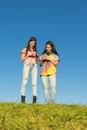 Two Teenage Girls Using Mobile In Park