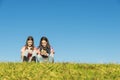 Two Teenage Girls Using Mobile In Park