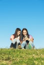 Two Teenage Girls Using Mobile In Park