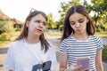 Two teenage girls are walking down the street and chatting in the summertime Royalty Free Stock Photo