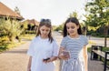 Two teenage girls are walking down the street and chatting in the summertime Royalty Free Stock Photo