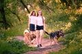 Two teenage girls walking with her dogs in park Royalty Free Stock Photo