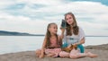 Two teenage are sitting on a sandy beach, on the Internet in phone. Royalty Free Stock Photo