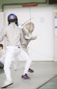 Two teenager fencers fighting with rapiers on the fencing tournament