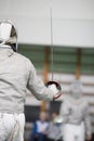 Two teenager fencers fighting with rapiers on the fencing tournament