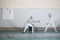 Two teenager fencers practicing their fighting with swords