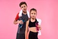 Best friends. Two teenagers boy and girl posing with towels and bottles of water after having workout isolated on pink Royalty Free Stock Photo