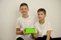 Two teenagers look at the screen of a smartphone. Two boys using mobile phone with green screen. Male teen phone screen Royalty Free Stock Photo