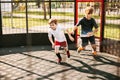 Two teenagers play freestyle soccer on a special Playground. Boys run after the ball. Sports, competition, friendship Royalty Free Stock Photo