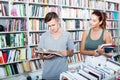 Two teenagers reading book together in book store Royalty Free Stock Photo