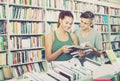 Two teenagers reading book together in shop Royalty Free Stock Photo