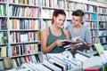 Two teenagers reading book together in shop Royalty Free Stock Photo