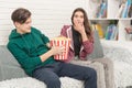 Two teenagers are sitting on the couch watching TV Royalty Free Stock Photo