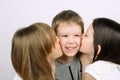 Two teens girls kissing little laughing boy Royalty Free Stock Photo