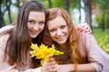 Two teens holding yellow leaves