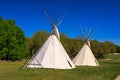 Two teepees are standing in a grassy field Royalty Free Stock Photo