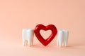 Two teeth and red heart on pastel background. Oral care and St. Valentine`s day concept