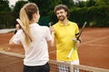 Two tennis players shaking hands at tennis court before the match