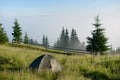 Two tents in the hikers camp in the mountains in sunny morning facing incredible rising fog from a valley Royalty Free Stock Photo