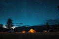 Two tents are placed on top of a vast grass-covered field, An idyllic camping scene under a twinkling starry summer sky, AI