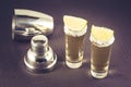 Two Tequila shot with lime and shaker/two Tequila shot with lime fruit and shaker on a dark stone background. Selective focus Royalty Free Stock Photo