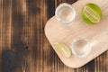 Two Tequila shots with lime slices and salt on wooden table/Tequila shots and lime slice on wooden table with Copy cpace. Top view Royalty Free Stock Photo