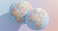 Two pastel colored globes side by side on a pink background, one light blue and one light pink, showing detailed world maps with Royalty Free Stock Photo