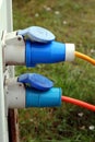 Two three pin outside power plugs connected to a campsite water and electricity supply point Royalty Free Stock Photo