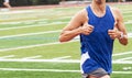 Two thumbs up by a runner running on a track