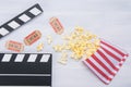 Two tickets to the cinema, on a wooden background in the arrangement of the movie clapper with a row strewn with popcorn Royalty Free Stock Photo
