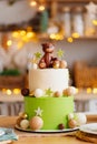 two-tiered white-green cake with balls, stars and teddy bear for birthday. Royalty Free Stock Photo