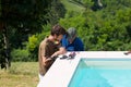 Two tilers working around swimming pool