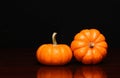 Two tiny pumpkins over black. Halloween