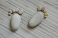 Two tiny stone feet and ten toes on wooden background, stone in the shape of a human feet Royalty Free Stock Photo