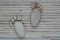 Two tiny stone feet and ten toes on wooden background, stone in the shape of a human feet Royalty Free Stock Photo