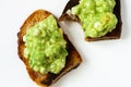 Two toast with avocado spred, one is biten Royalty Free Stock Photo