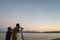 Two toddler brothers observing sky and stars with a telescope