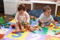 Two toddlers playing with toys sitting on floor at kindergarten Royalty Free Stock Photo
