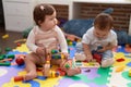 Two toddlers playing with toys sitting on floor at kindergarten Royalty Free Stock Photo