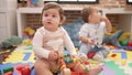 Two toddlers playing with toys sitting on floor at kindergarten Royalty Free Stock Photo