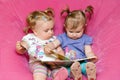 Two toddlers reading together