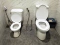 Two toilet seats installed together in one bathroom, a big one is for adults and a small one is for kids. Restroom with two toilet